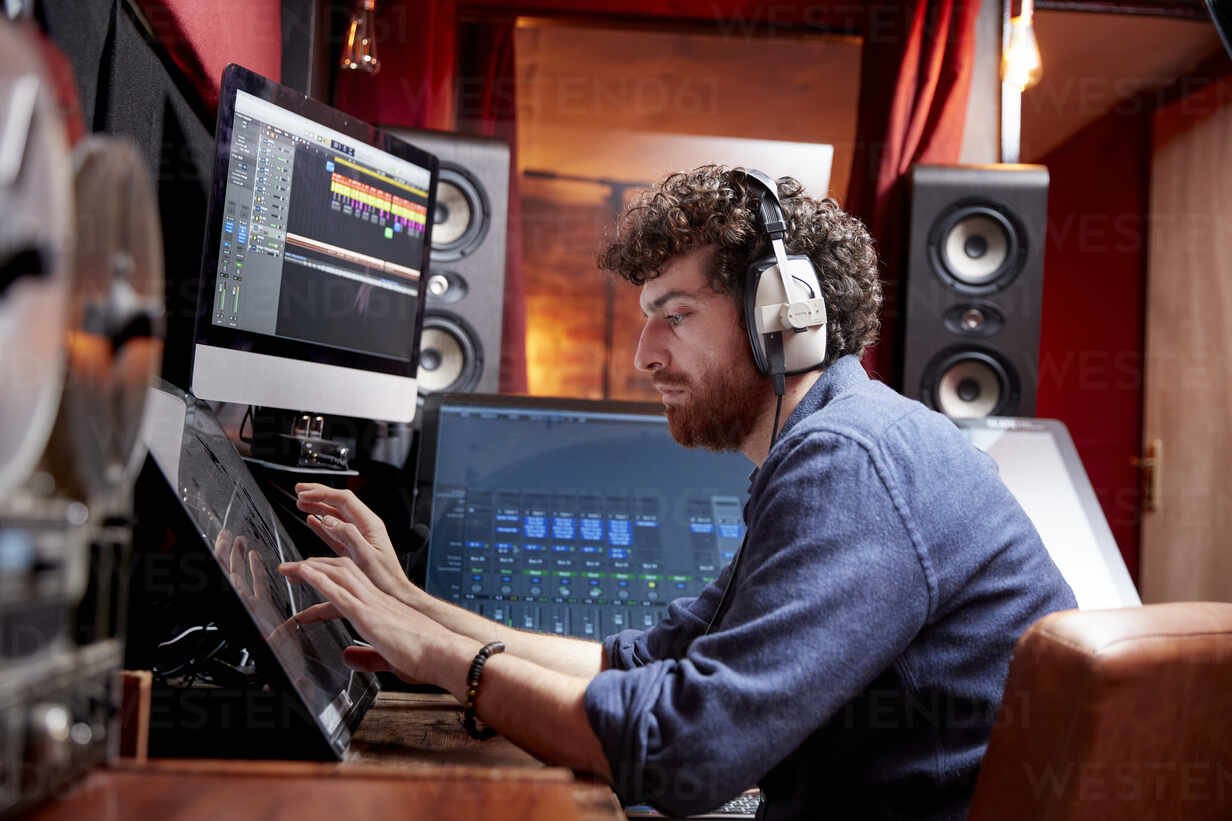 man-working-in-music-studio-using-computer-wearing-head-phones-MINF16229.jpg