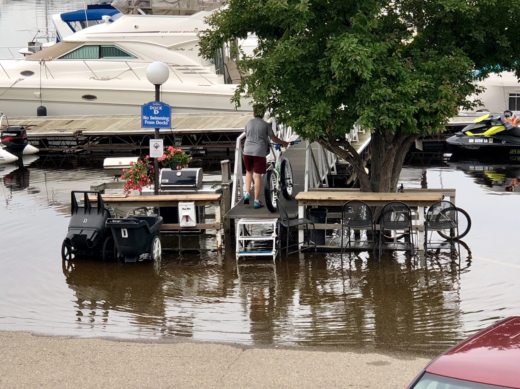 I watched this young man lift his bike up over the waterline in another section of the same parking lot, but wasn't able to get a photo until after he had waded through the water and made it up the steps. 