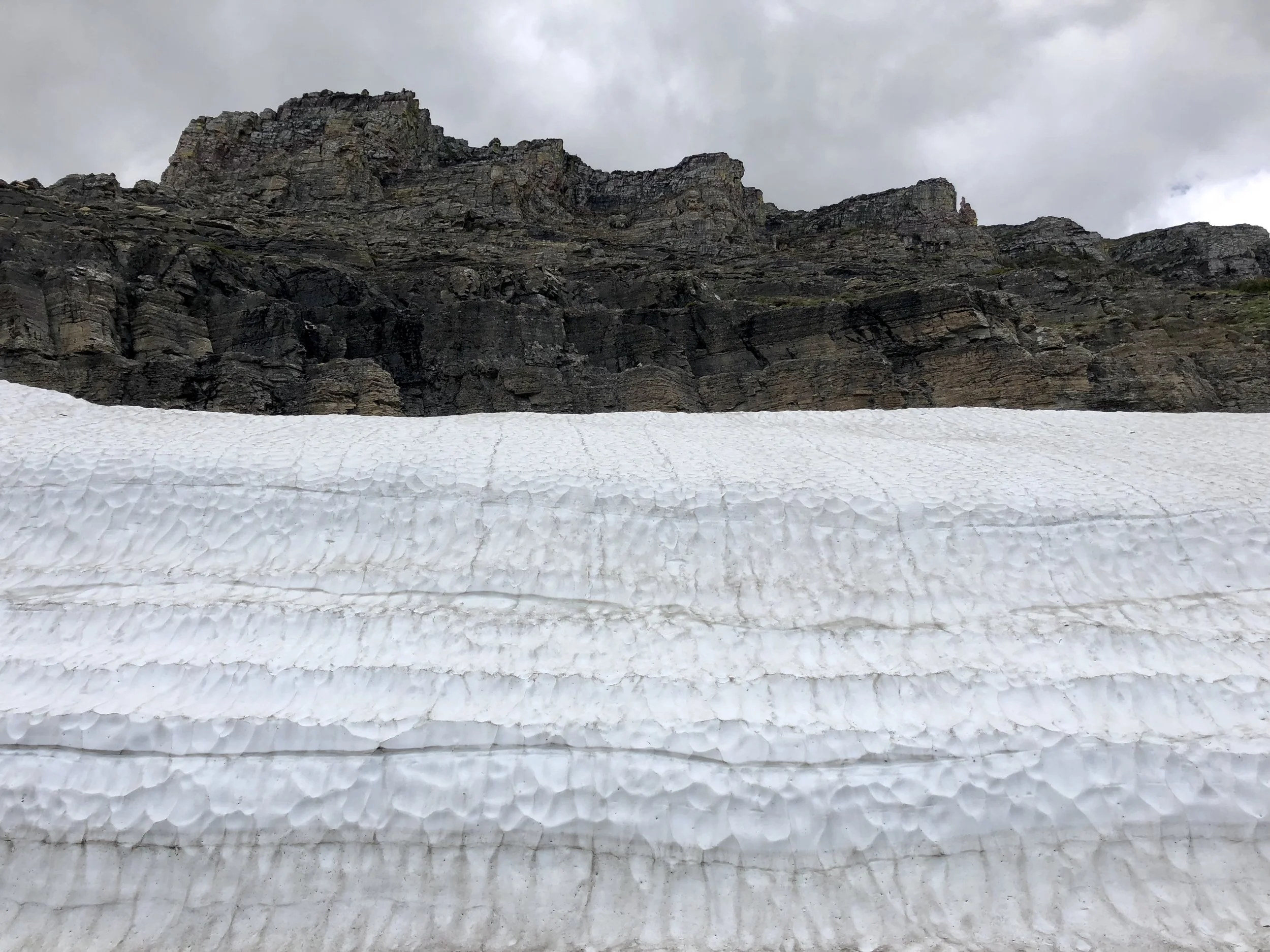 It's hard to distinguish a glacier from a snowpack at first glance, but glaciers are made of ice. This is snow butting up against a rock face. Most likely, this will be gone in a few weeks. Glaciers in this park, on the other hand, are at least 7000…