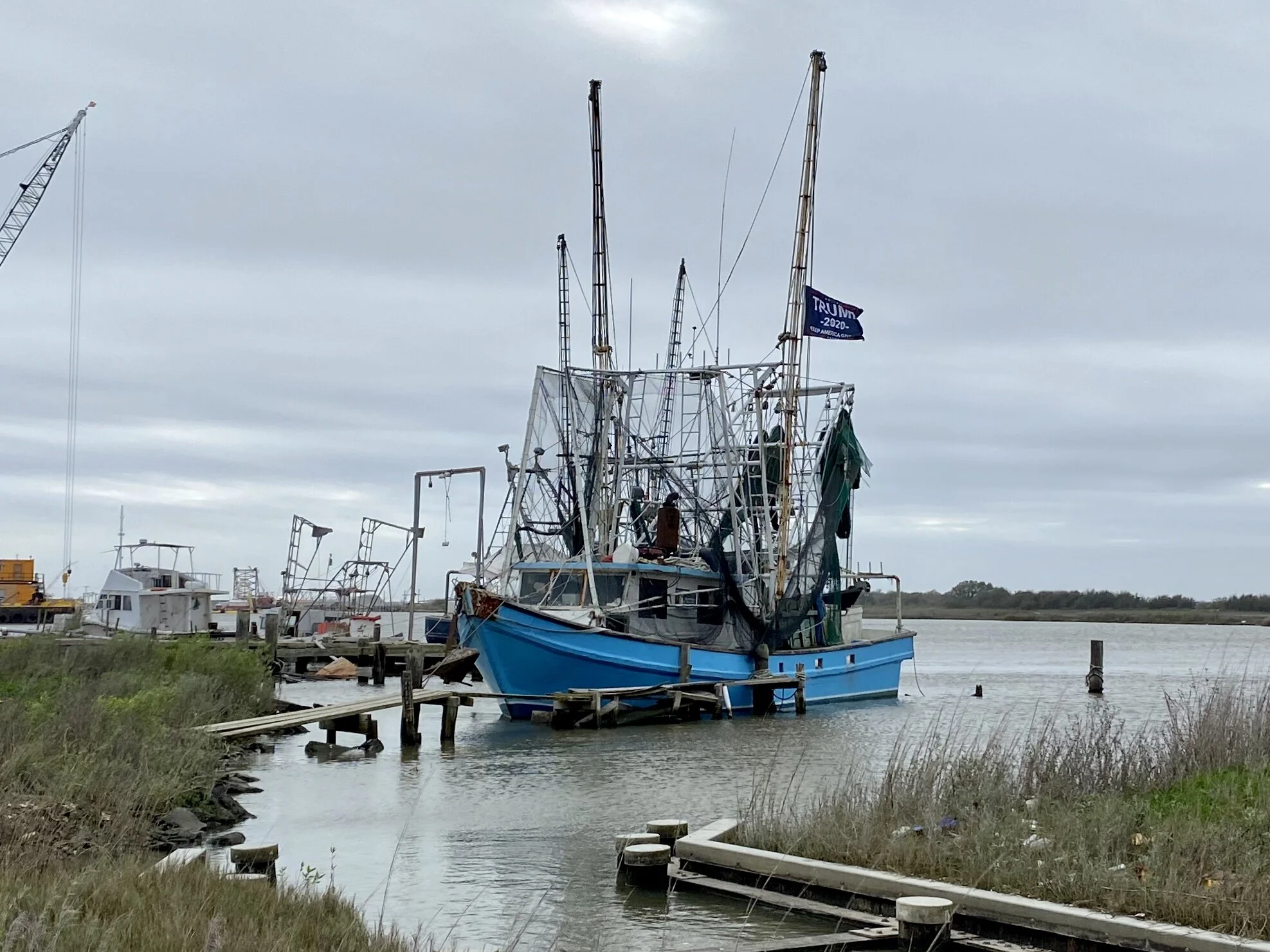 A fishing boat moored near the site of the new LNG global exporting plant at Cameron, LA. The flag on the boat says Trump/Pence 2020 . The entire port area just south of this boat (which used to be public land) is now privately owned by the company …