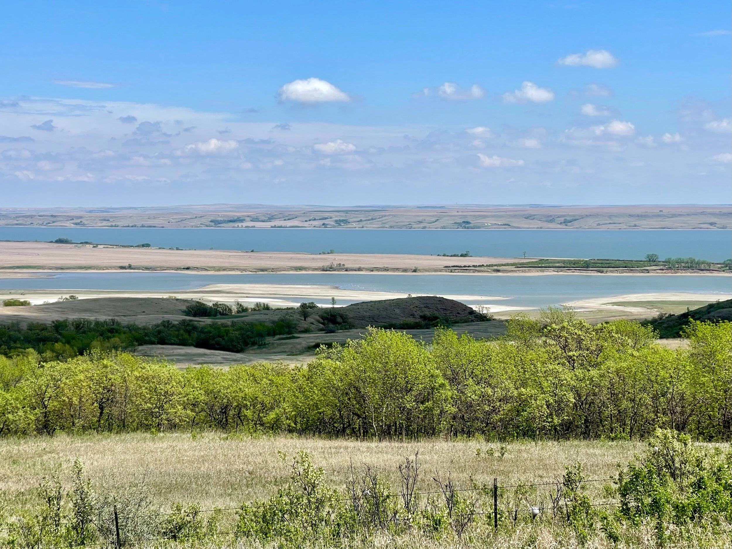 The Missouri River from Standing Rock Reservation. We cycled the entire length of the Reservation on Highway 1806 and were deeply impressed with the beauty of the environment. At one point near Fort Yates, a woman waved Jenny over to point out the Sitting Bull Sacred Horses  on a hill. An omen of good luck for those who see them, these wild horses are regarded as descendants of Sitting Bull’s horses. Photo by Michael Chase.