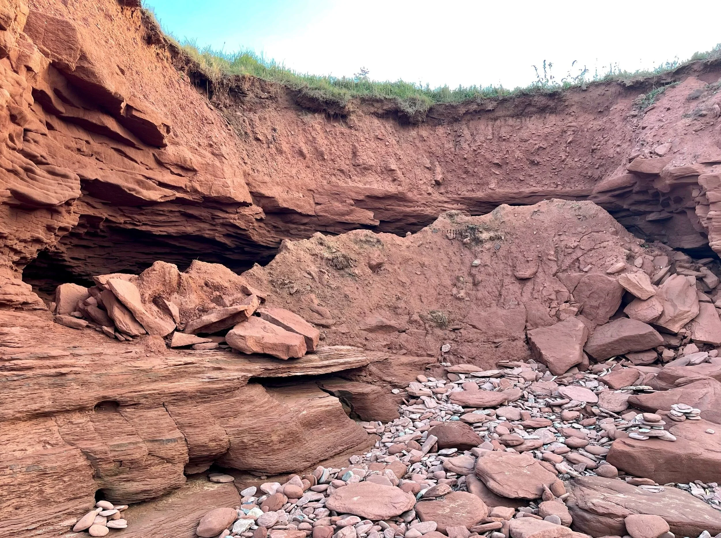 Taken on the north shore of PEI not far from Cabot Provincial Park, this picture demonstrates how erosion works on the shoreline. Waves wear away the sandstone cliffs until they collapse from underneath. Because of sea-level rise and increased storm surges, PEI has been losing an average of about two feet a year of its shoreline. Scientists expect the rate of erosion to worsen in the future. Other impacts of climate change on PEI include steadily rising average temperatures, milder winters with less snow, increasing swings between excessive drought and precipitation events, and greater exposure to extreme weather events such as hurricanes, storm surges and destructive winds. Photo by Michael Chase. Follow him on Instagram @mjohnsonchase.