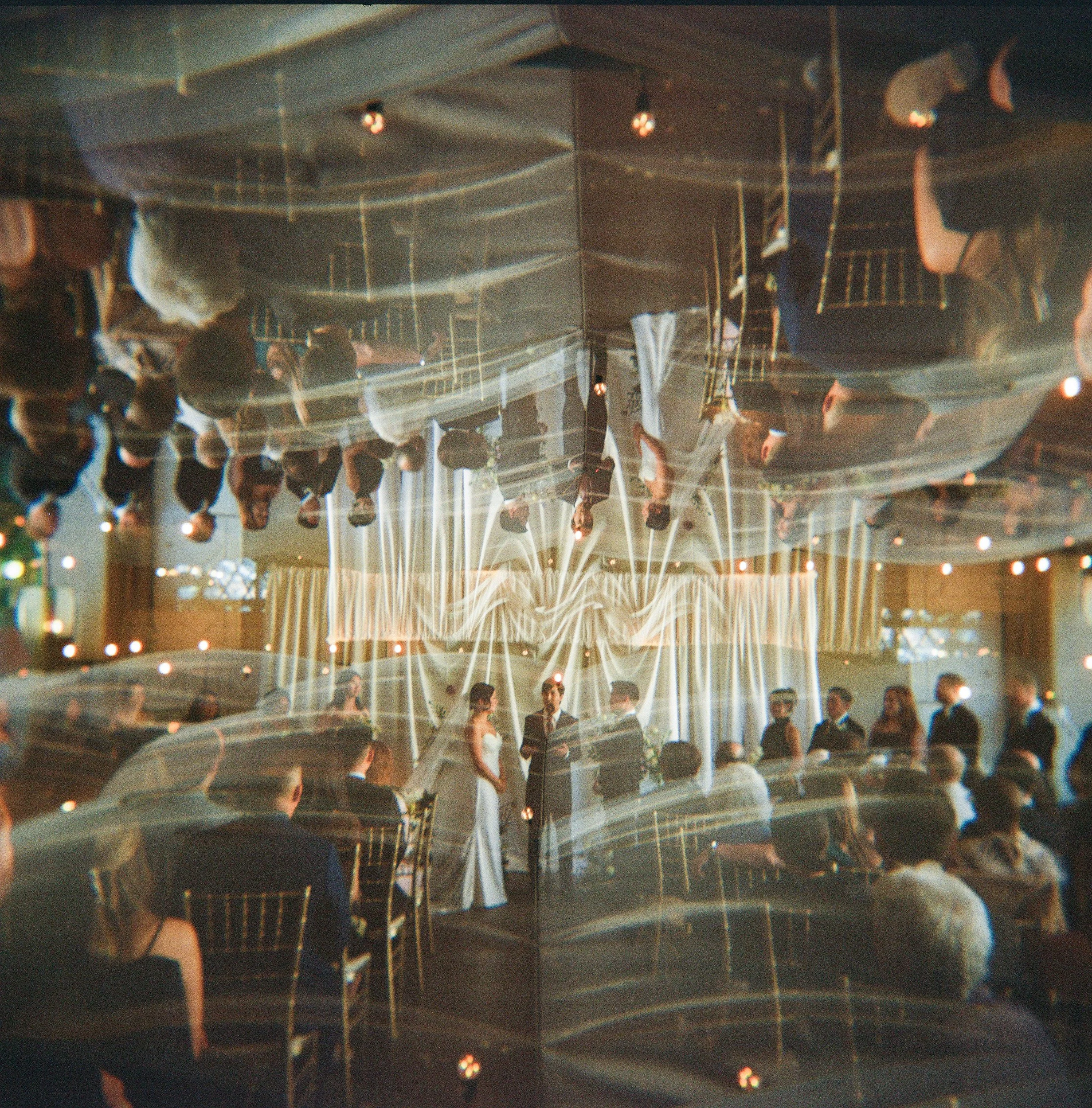 A group of people at a wedding on the terrace of the Berkeley City Club, photographed on a Holga 120 with double exposure which mirror flips the image.