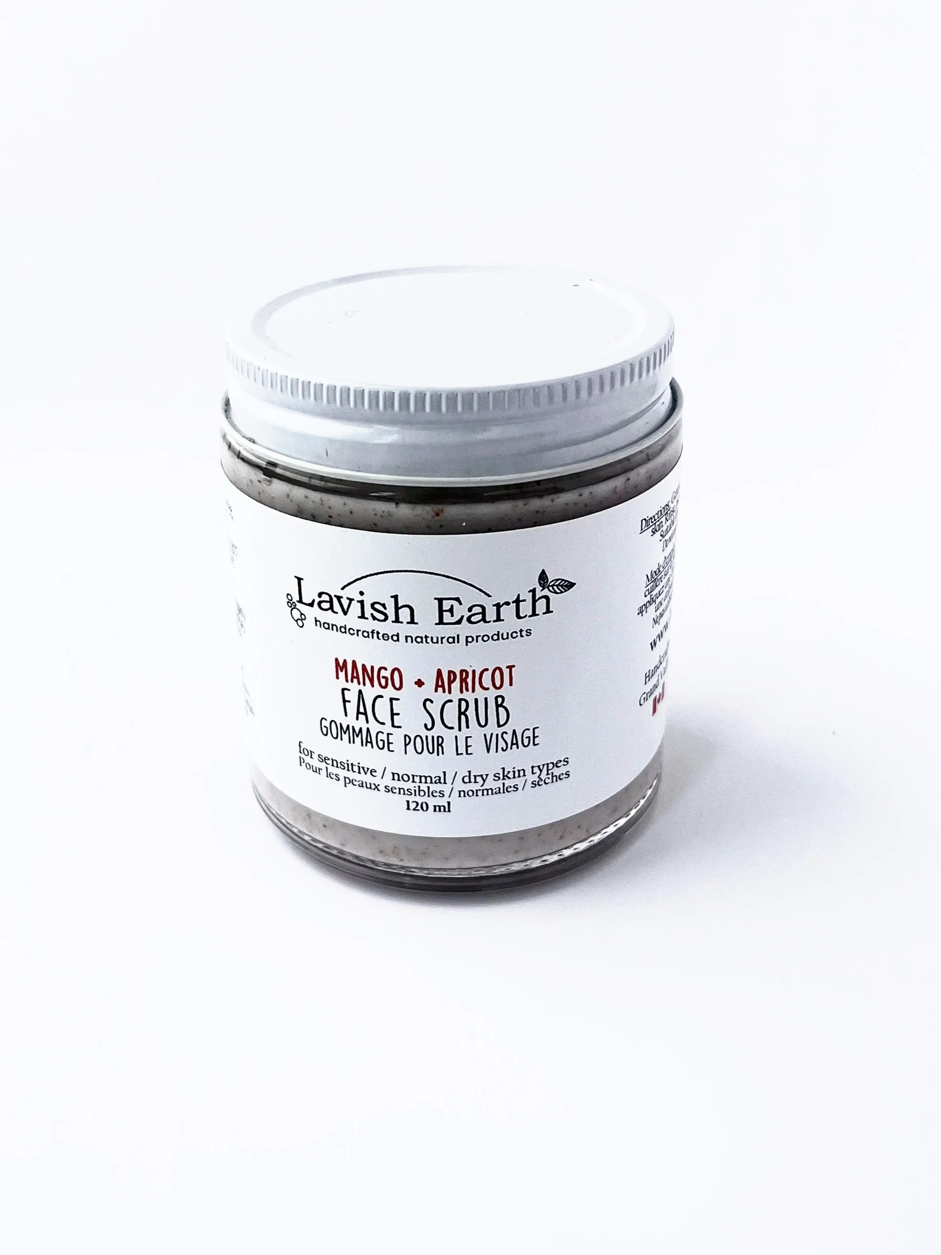 Lavish Earth Mango Apricot Shell exfoliant in creamy lotion texture shown packaged in glass jar with metal lid Ontario