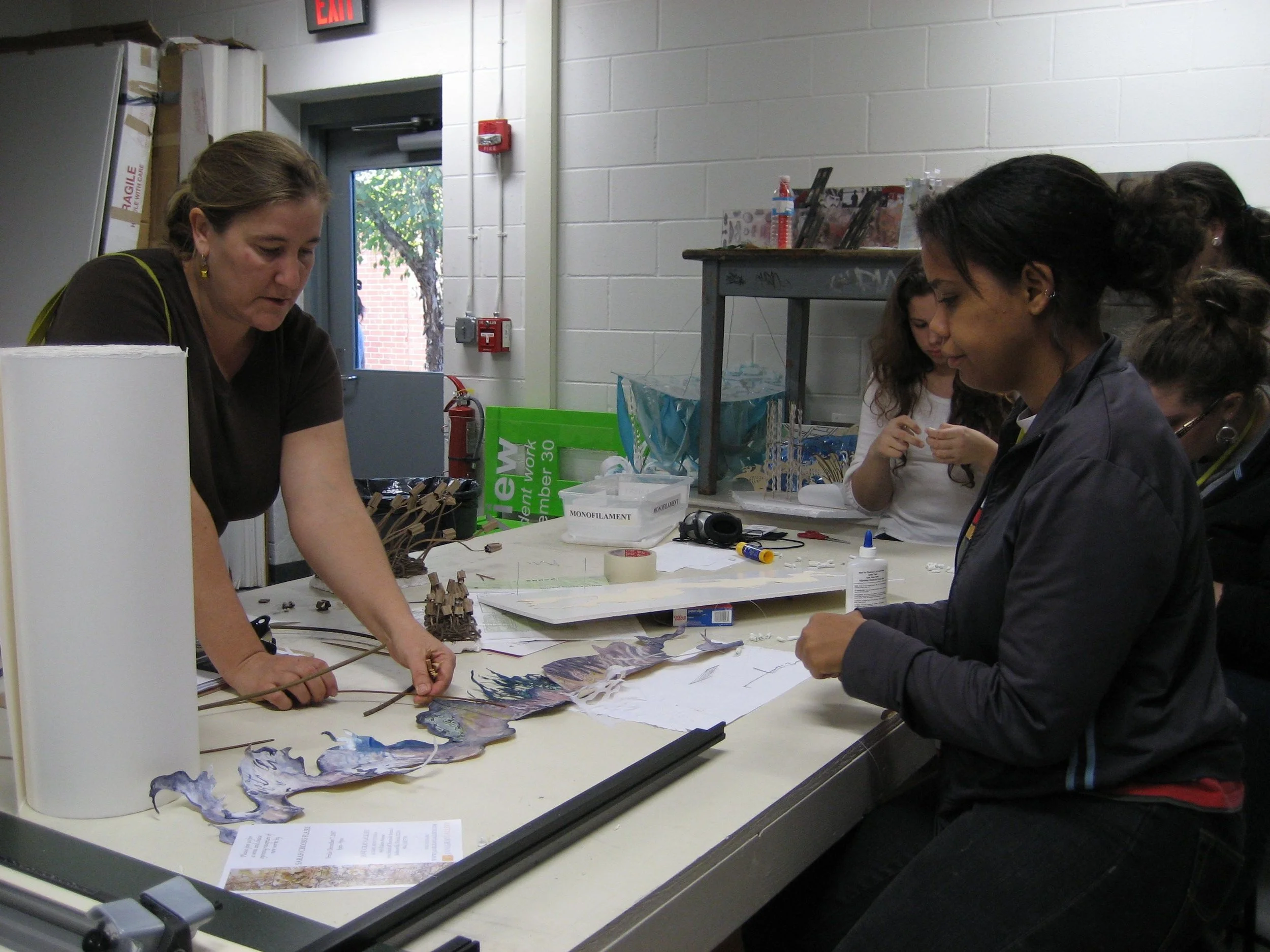 one on one with students discussing the model