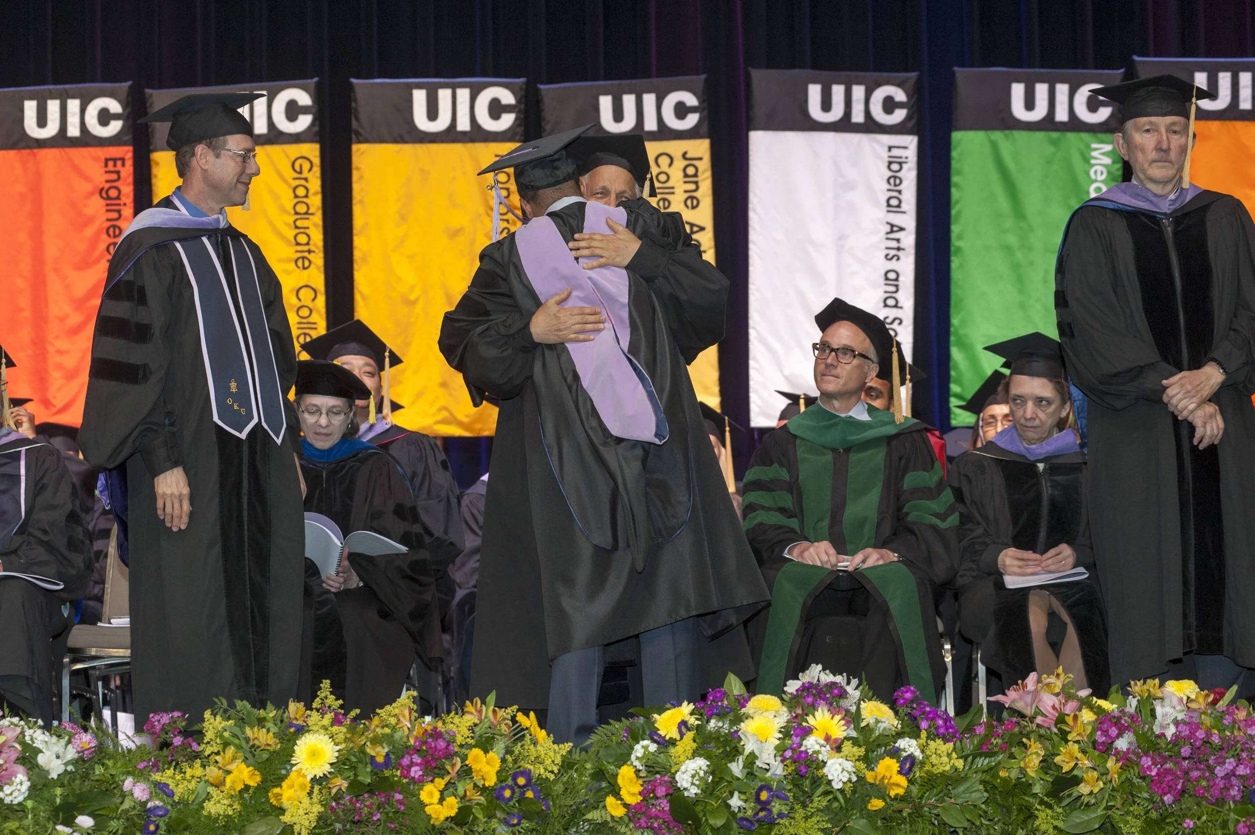 Dr. Adel embraces his son, Dr. Paul,&nbsp;after awarding him his doctoral hood on the day of his graduation from the UIC College of Dentistry.
