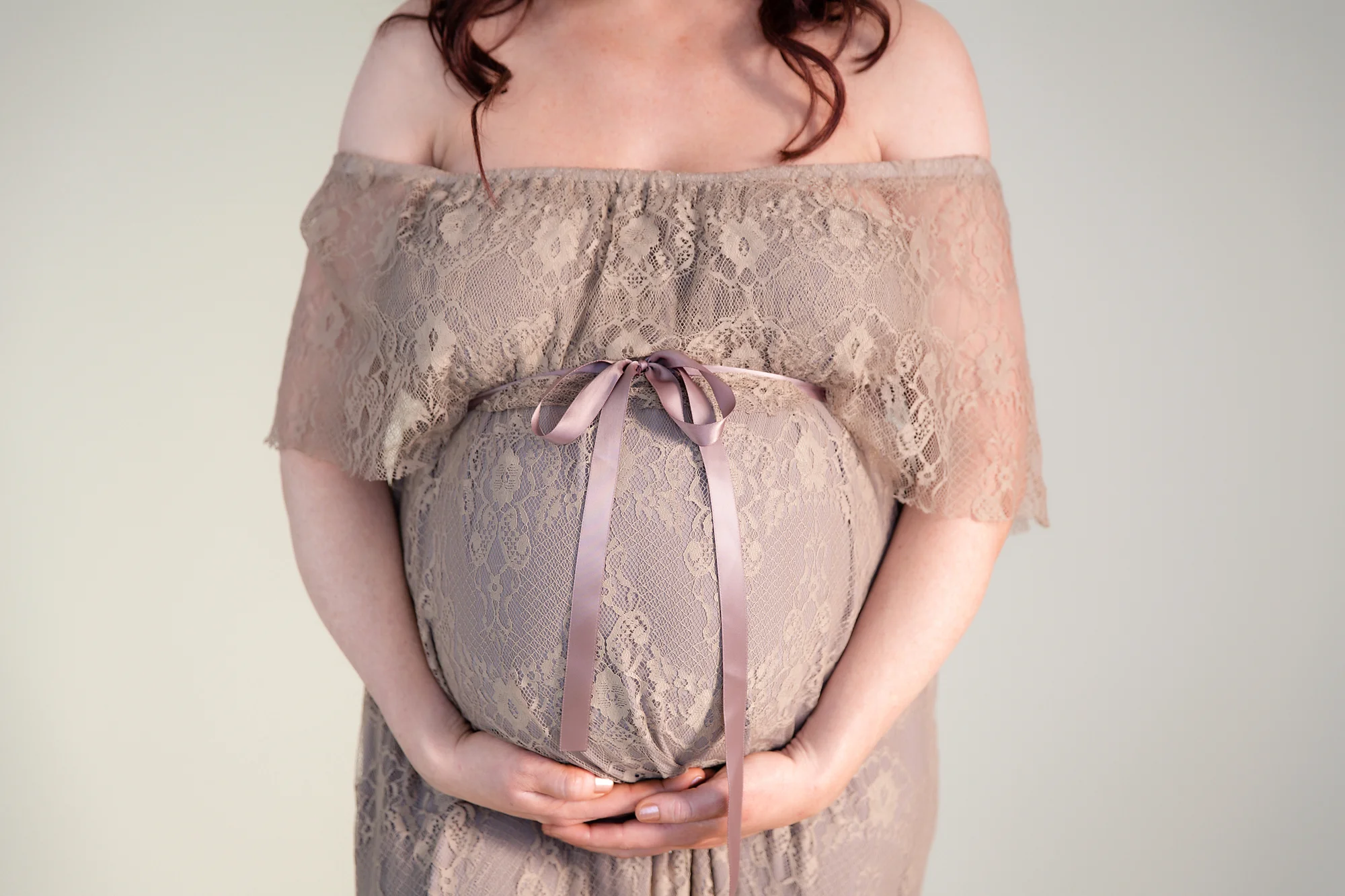Belly wrapped like a present with a bow. Maternity photoshoot idea. Calgary maternity photographer