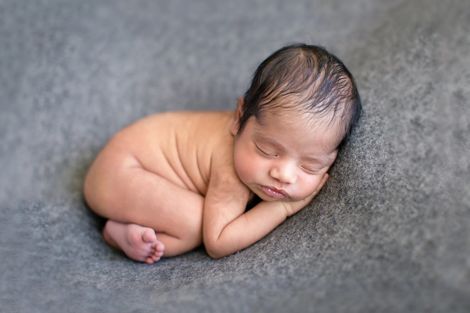 Newborn baby boy on a grey backdrop. Bum up pose - newborn photography. Calgary newborn photographer.
