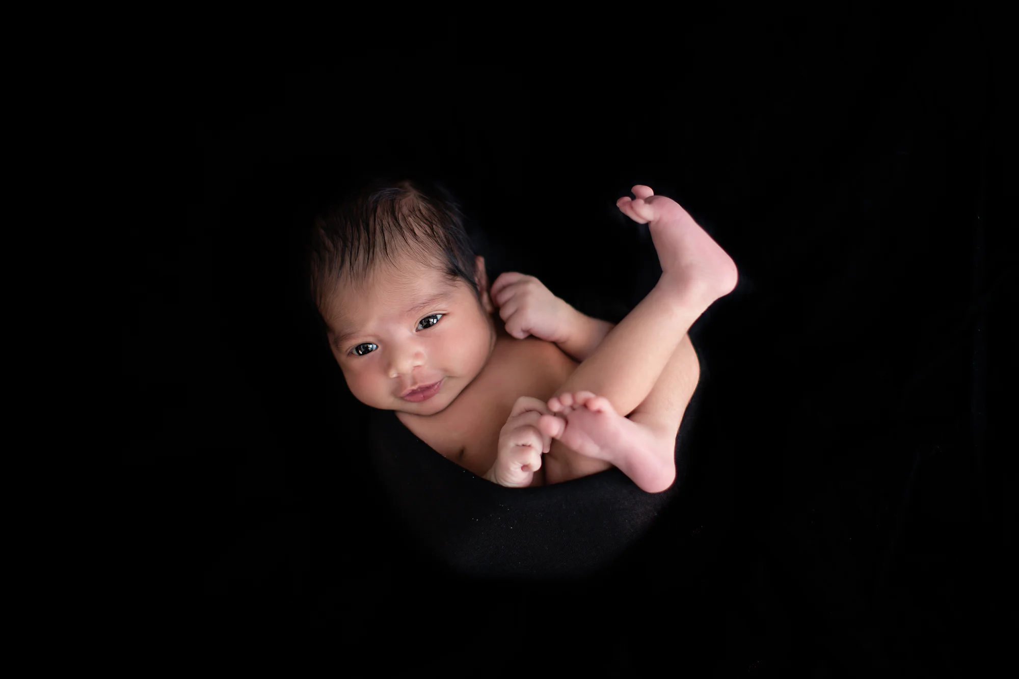 Baby boy smiling and looking right at the camera. Newborn photography ideas. Calgary Photographer.