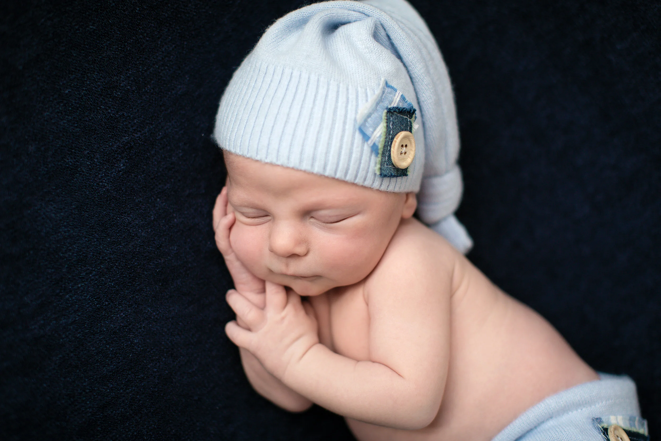 Beautiful little baby boy is sleeping soundly on a beanbag. Newborn Photoshoot in Calgary, Alberta, Canada. Milashka Photography