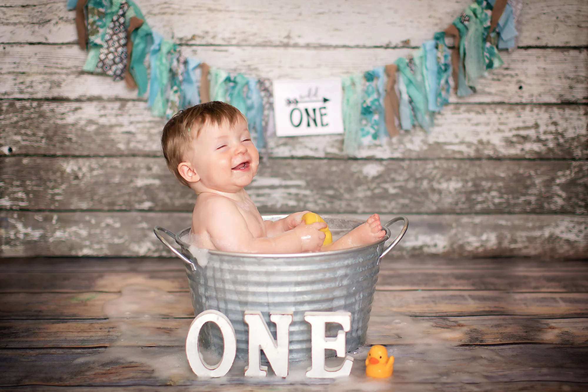 Birthday boy is enjoying his bubble bath after his cakesmash action. Airdrie Cakesmash Photographer - Milashka Photography