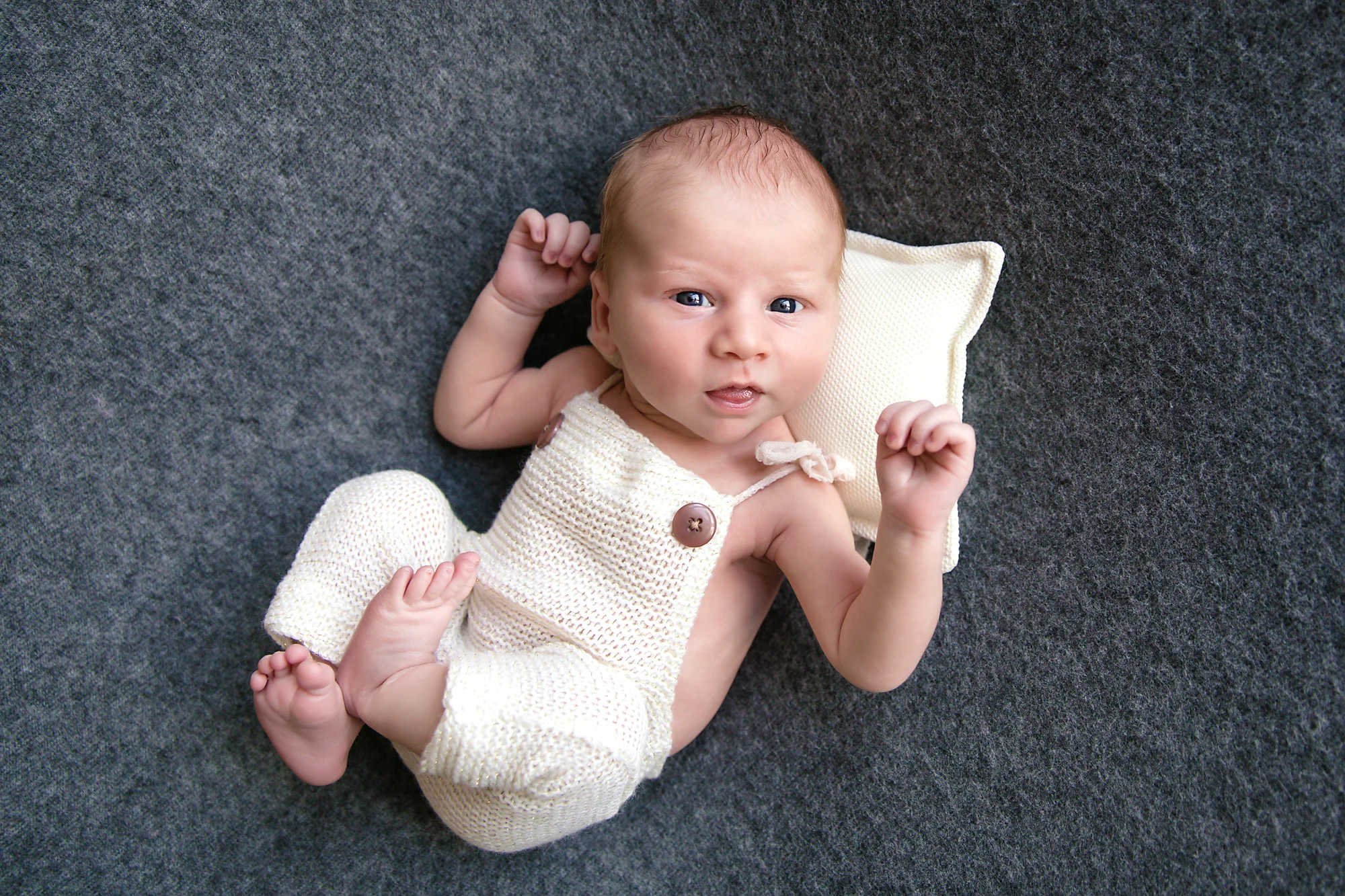Newborn baby boy is looking right at the camera. Calgary Newborn and Baby photographer - Milashka Photography.