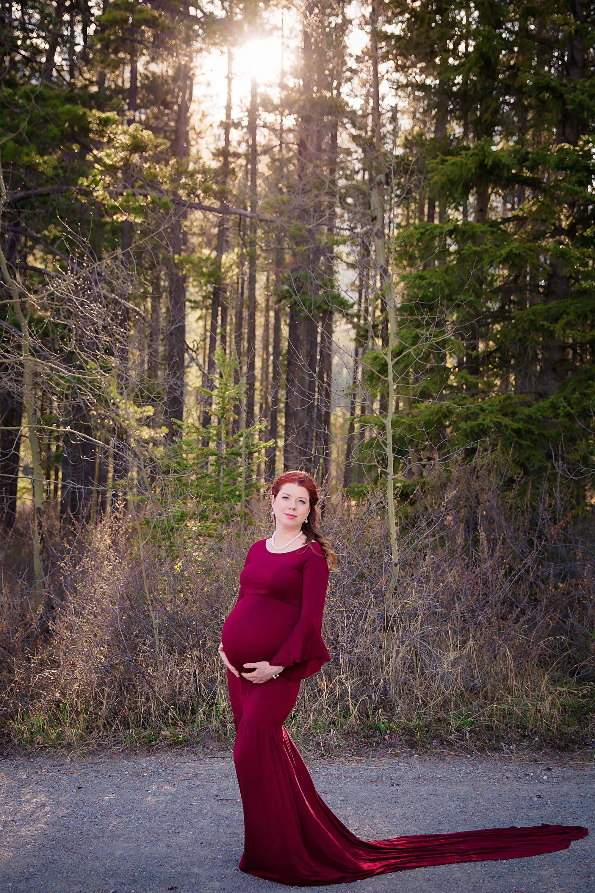 Mom-to-be in a red gown is posing for the camera in this maternity session.