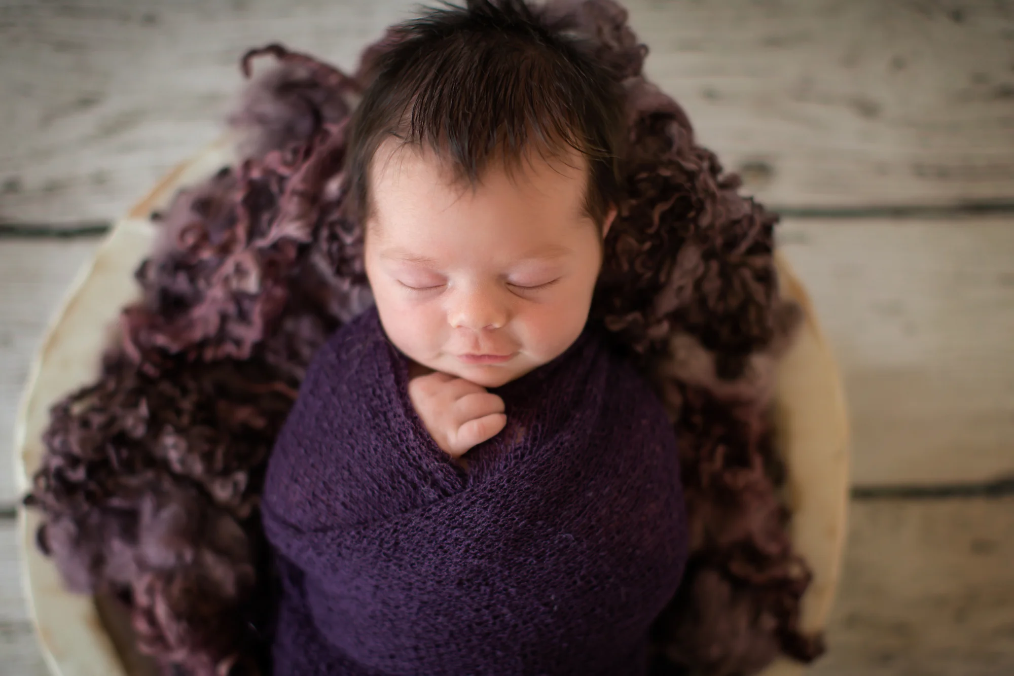 Newborn baby girl photoshoot idea. Baby girl is posed in a bowl and is smiling in her sleep.