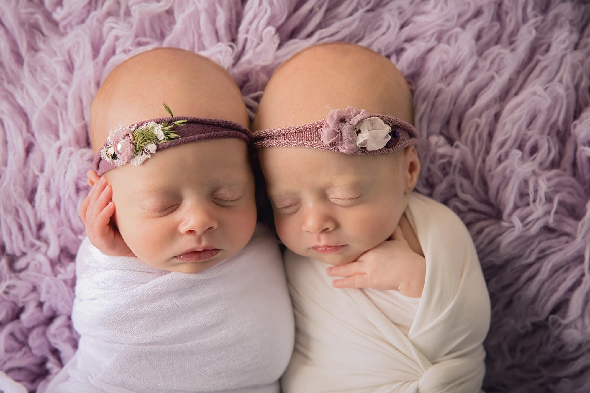 Twins Photography in Calgary, Alberta by Milashka Photography. Twin sisters are posed on a lilac flokati rug.