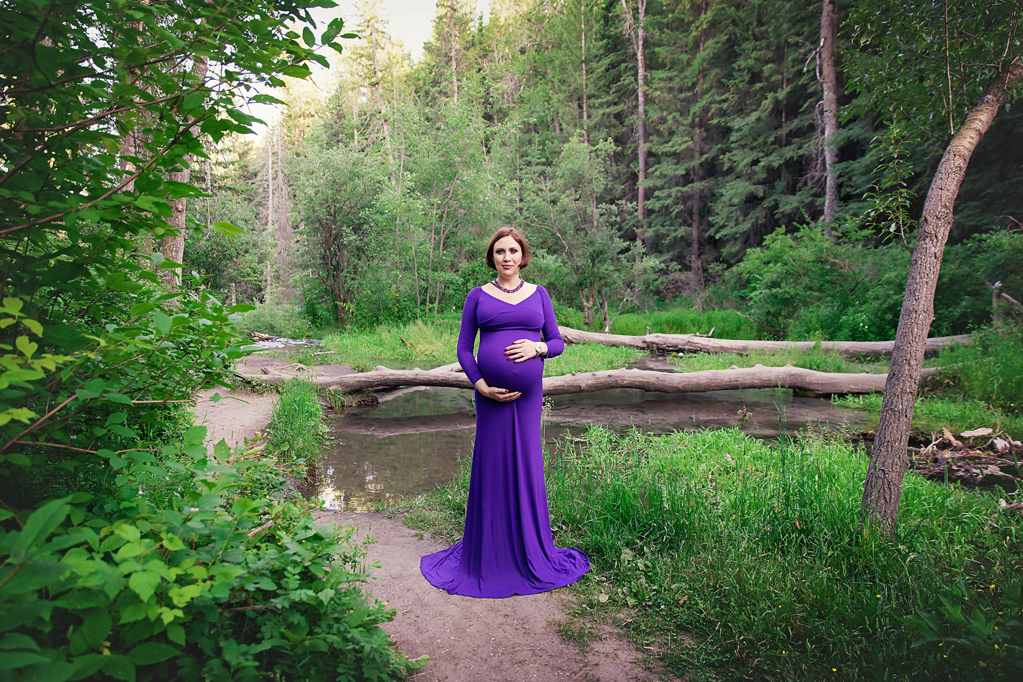 Mom-to-be in a purple gown in a forest. Calgary and Airdrie Maternity photographer