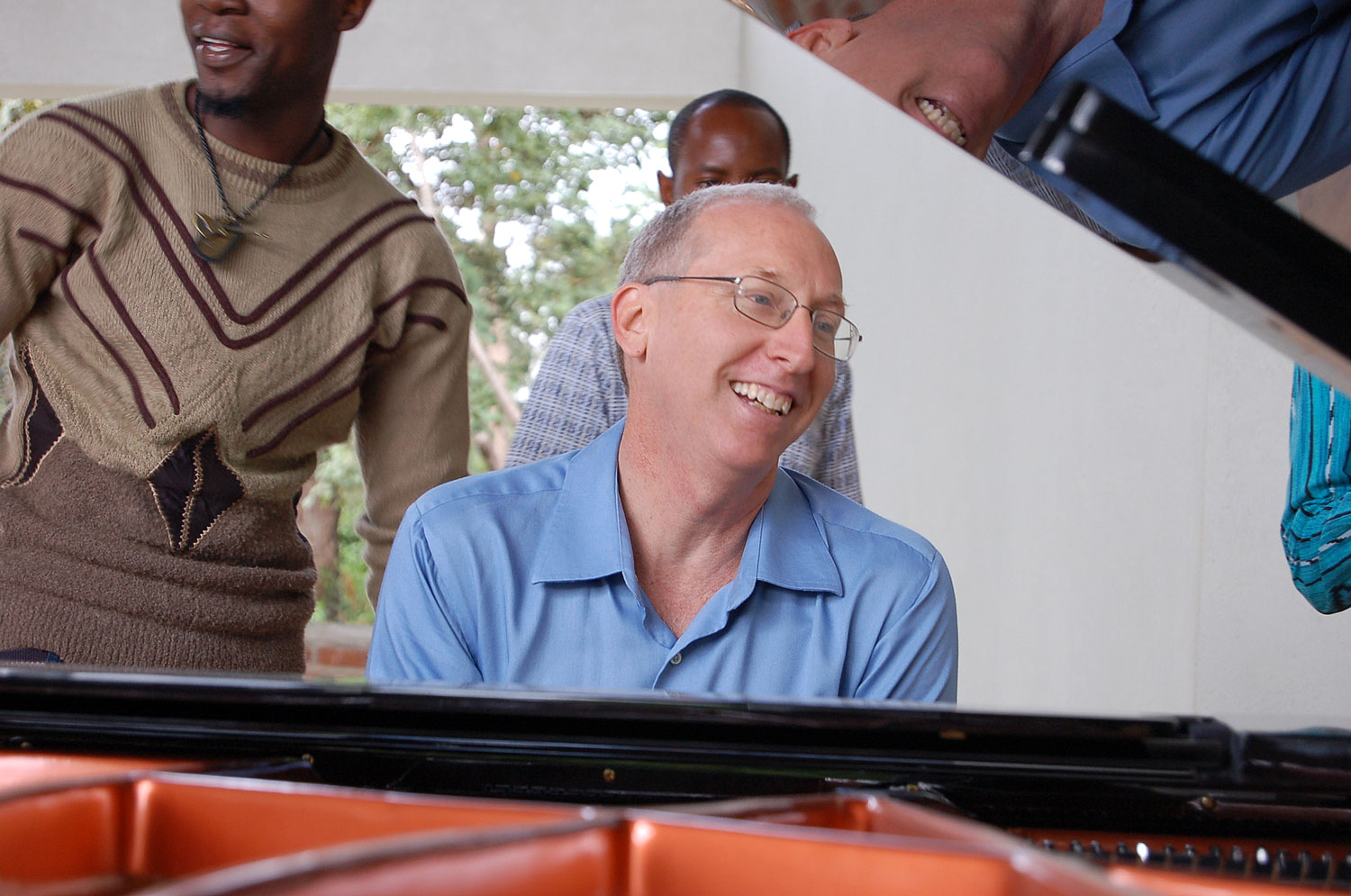  CAC Programme Manager smiles as he listens to the sounds of the grand piano that was donated to Tumaini University Makumira by generous friends in the United States of America. 