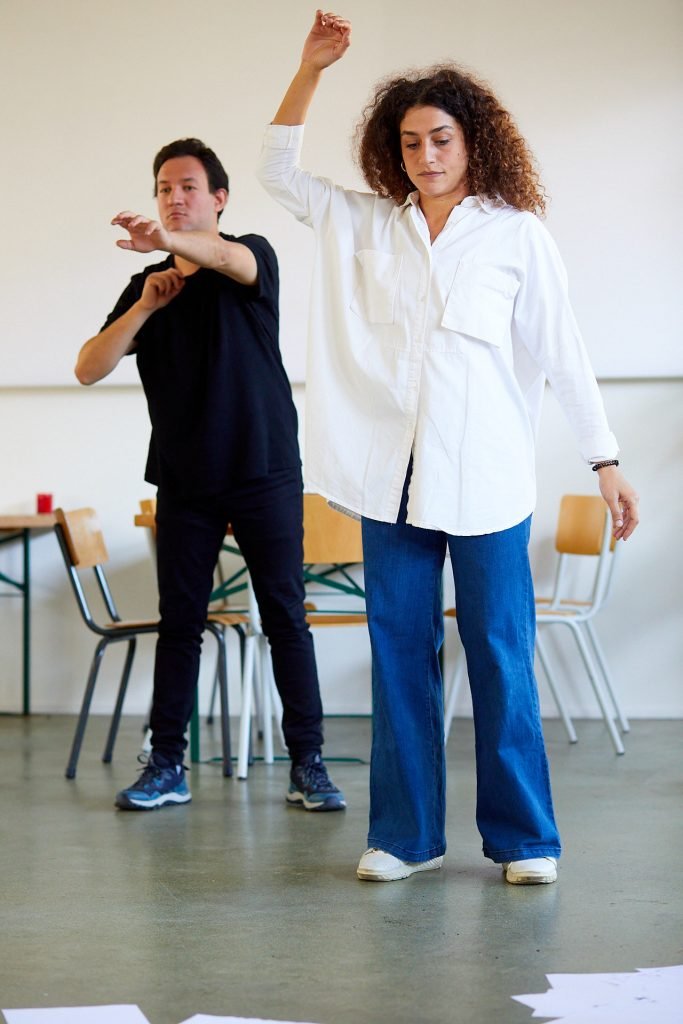 Two participants performing, standing and stretching their arms.