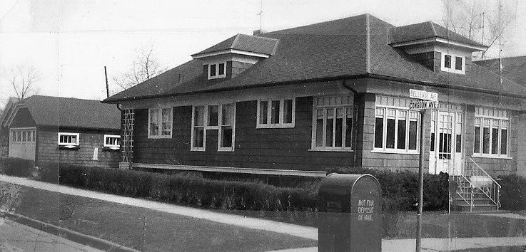 Black-and-white photo of a single-story bungalow on a street corner with a curbside mailbox and street signs reading "Bellevue Ave" and "Congdon Ave."
