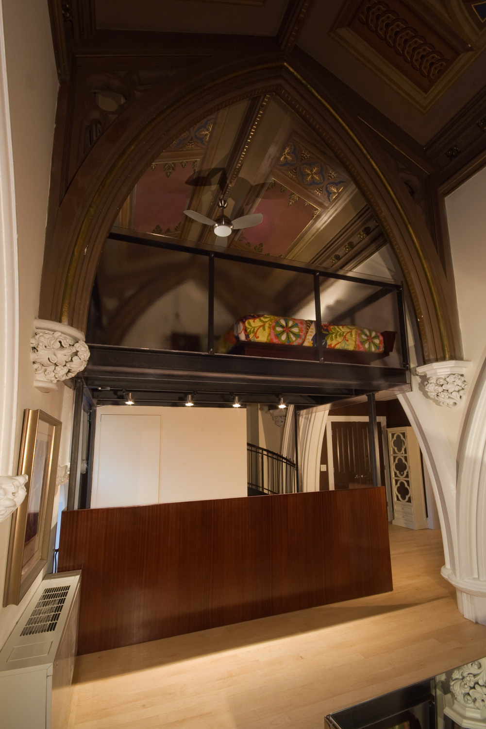 The raising of the bed enables a new experience: sleeping up amongst the gothic arches. 