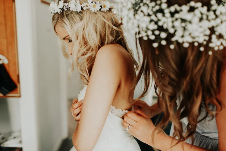 boho bride being zipped into wedding dress in chesham wedding