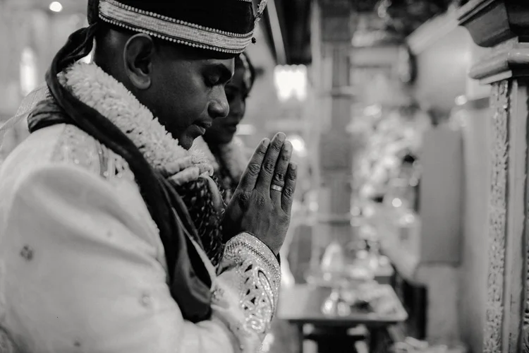 indian groom prays to god in hindu temple