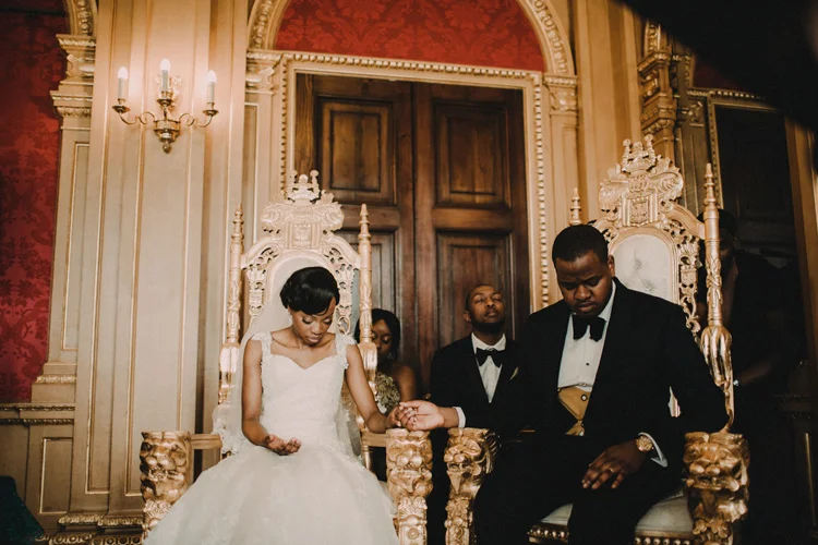 bride and groom hold hands whilst praying in hylands house wedding