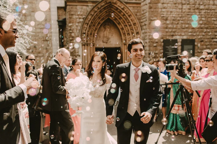 asian bride and groom recessional with bubbles in london city wedding
