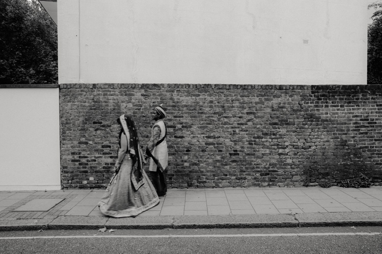 indian bride and groom hold hands walking after hindu ceremony