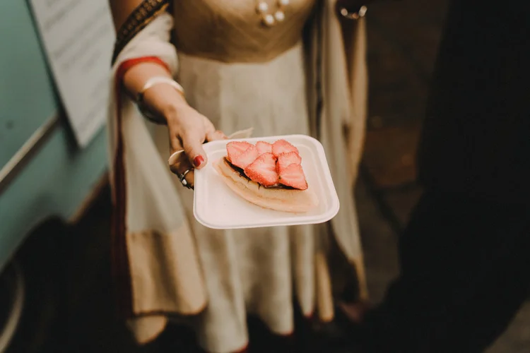 hindu bride shows dessert at hindu wedding reception