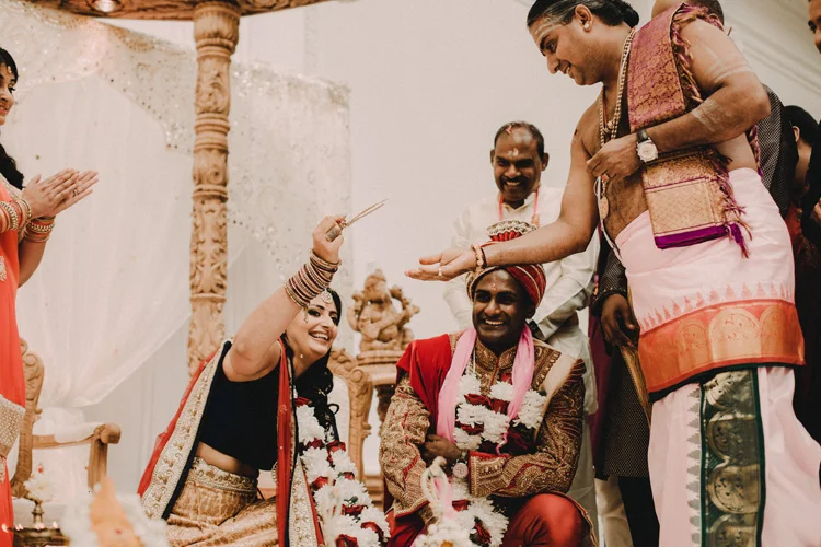 indian bride and groom play fishing the ring in hindu ceremony