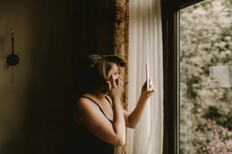 bride looks into mirror during bridal prep