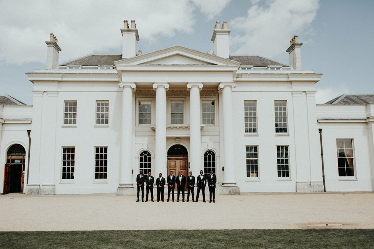 groomsmen stand in front of hylands house