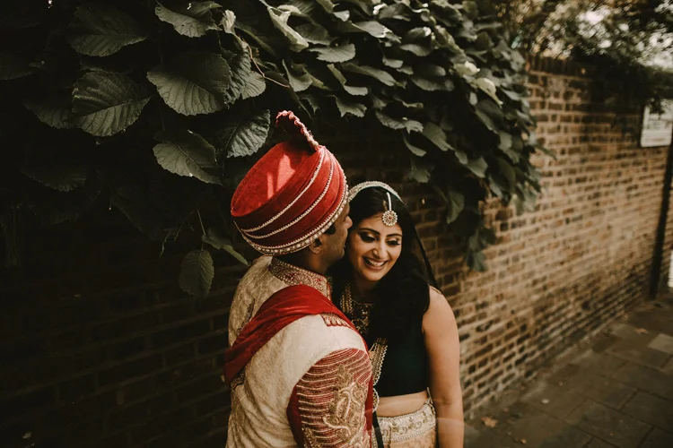 indian groom kisses indian bride on london street after hindu ceremony