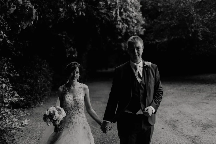 bride and groom holding hand in the wind in quex park wedding