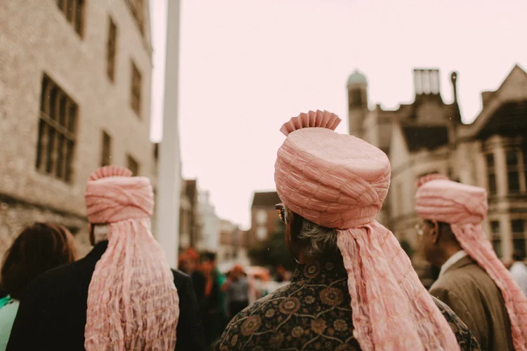 asian family members standing with turbans in the rain