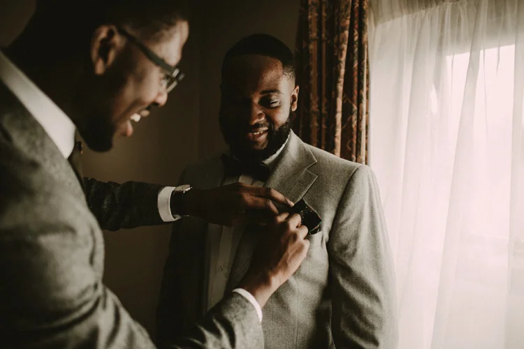 best man helps groom to get ready in froyle park wedding