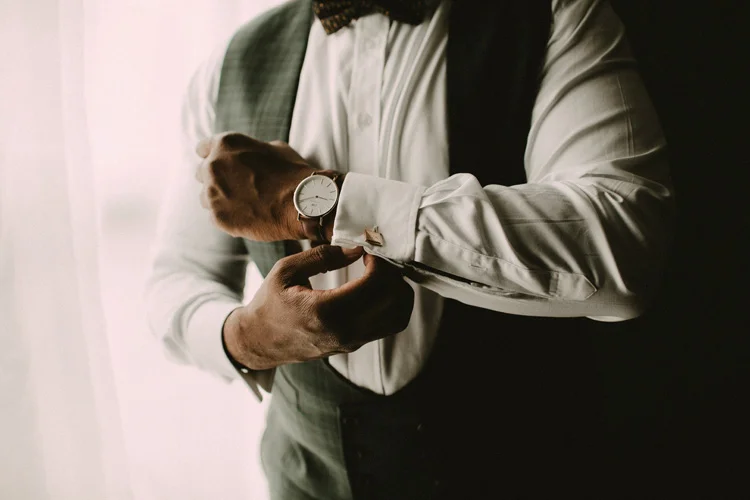 groom puts on watch before syon park wedding