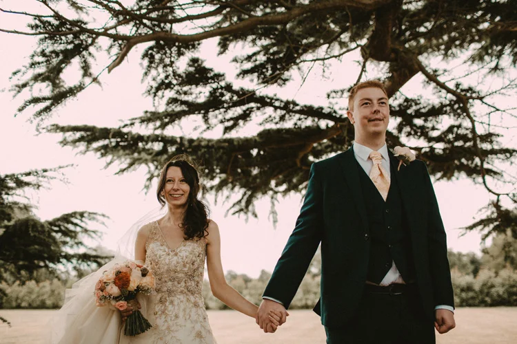 bride and groom holding hands after ceremony at quex park wedding