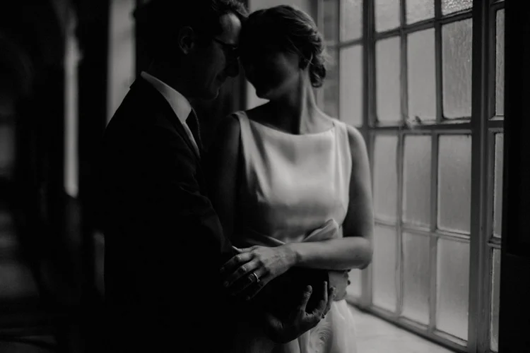 french groom holds russian bride in intimate moment in islington wedding