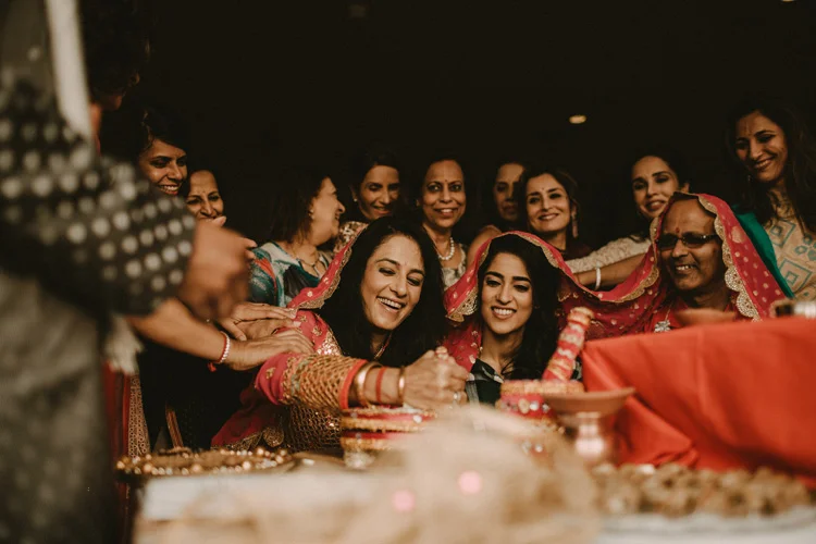 bride and her mum laugh during hindu ritual in puja