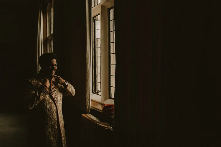 groom laughs with best man before hindu ceremony in southampton wedding