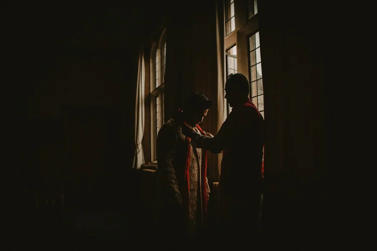best man helping groom get ready before this traditional hindu ceremony