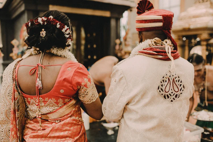 bride and groom pray in hindu temple after traditional hindu wedding