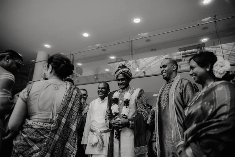 indian groom greeted at hindu ceremony by family members and conducts ritual in london hindu wedding
