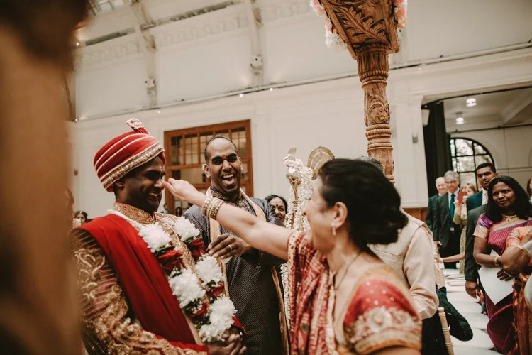 grooms mother jokes with groom before entering the mandap in london hindu wedding