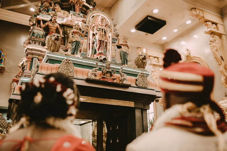 hindu bride and groom pay respect to god in hindu temple