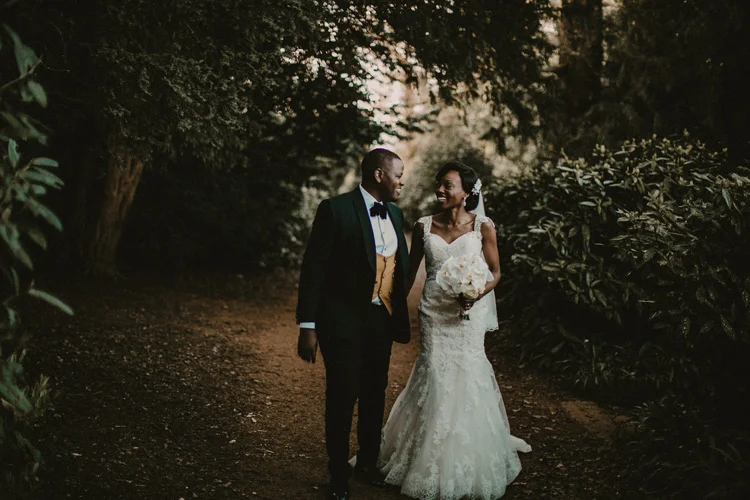 african bride and groom hold hands and share laugh at hylands house wedding