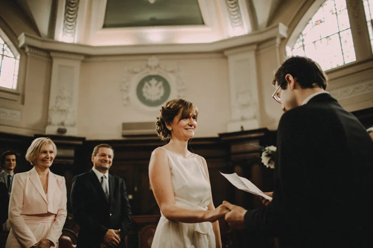 french groom recites wedding vows to russian bride in islington wedding