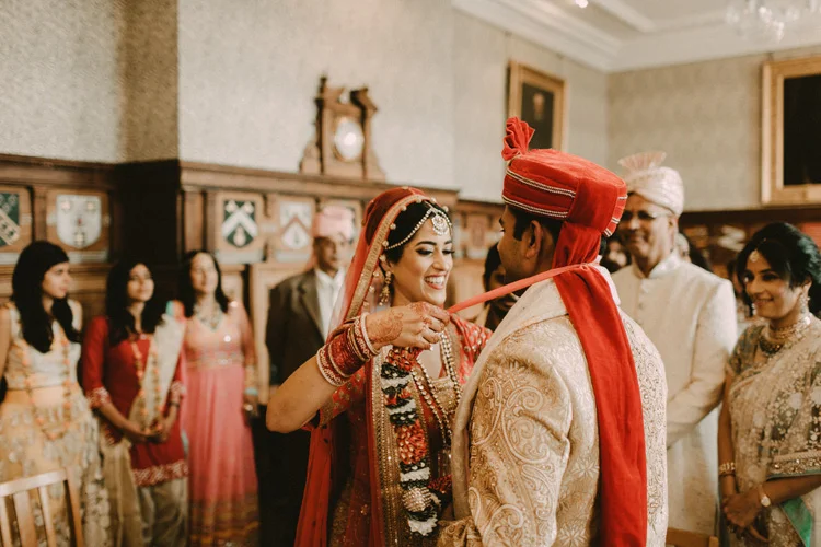 hindu bride ties garland around grooms neck in hindu ceremony at the great hall